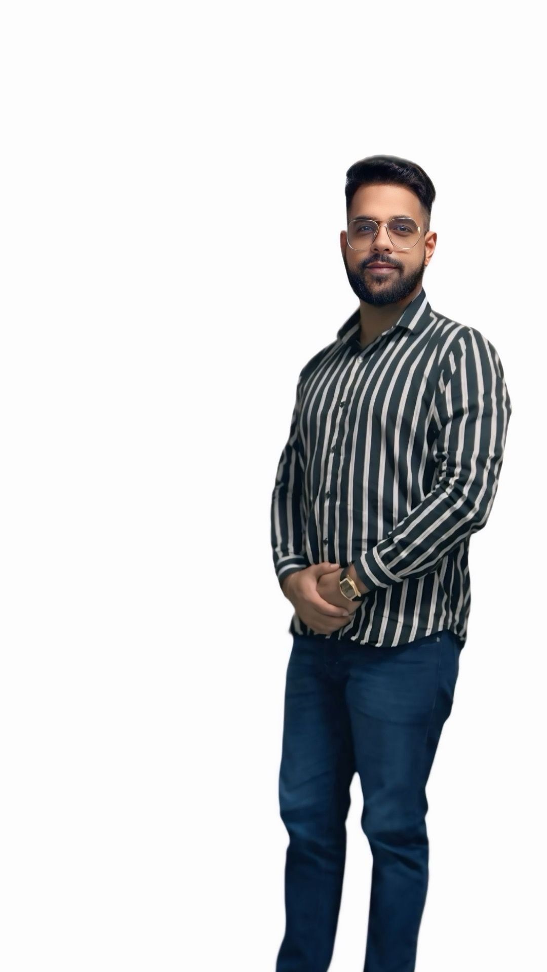 Man in a striped shirt and jeans standing in front of a white background.